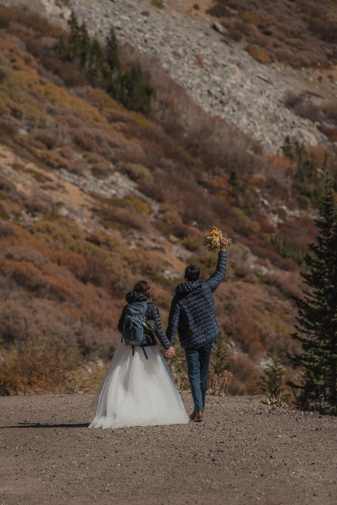 couple hiking down mountain during their elopement in the mountains