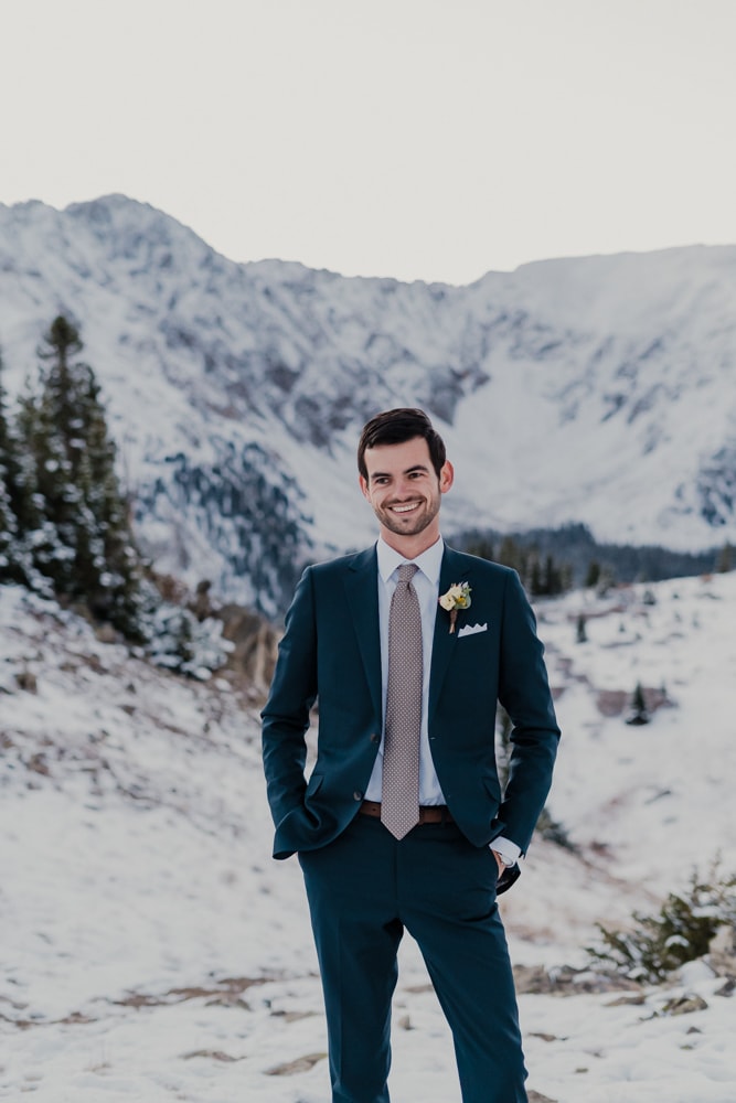 Groom taking individual photo during her elopement at loveland pass