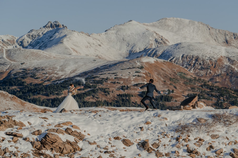 couple having snowball fight on their elopement day at loveland pass